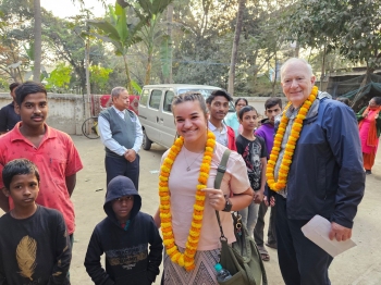 Mackinzie Reinert poses with children and adults affected by HIV